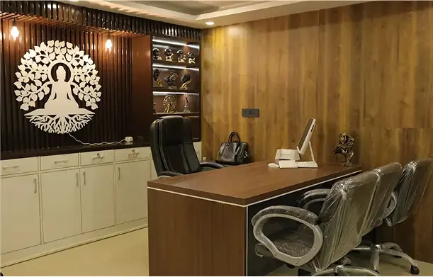HavenHub Infra's office cabin with a wooden desk, leather chairs and a carved tree panel on the wall