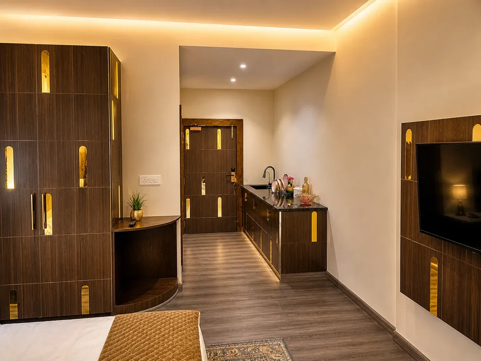 A studio apartment entrance with a kitchenette and wooden wardrobes
