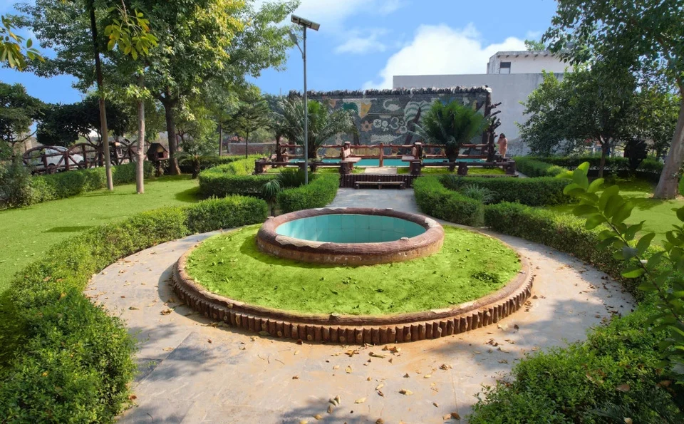 A landscaped garden with a round fountain at Mahadev Vihar