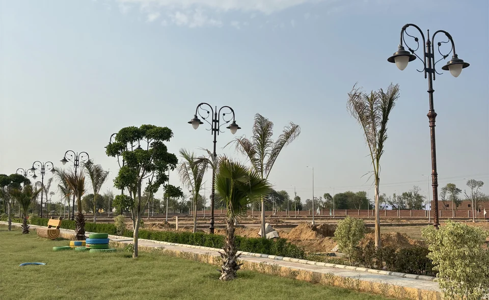 A landscaped park with lamps and young palms