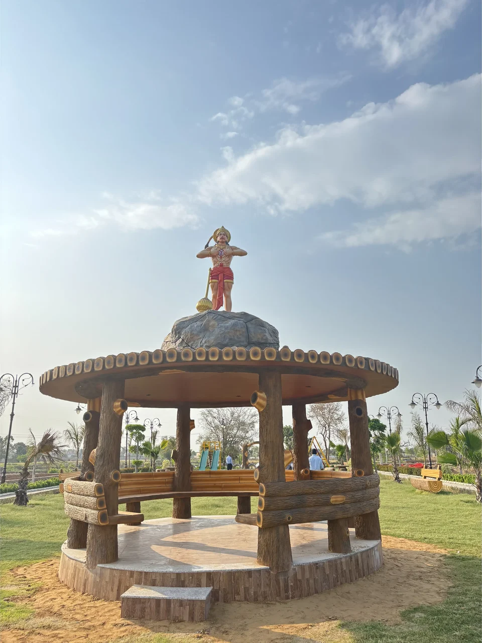 A gazebo topped with a statue in the park