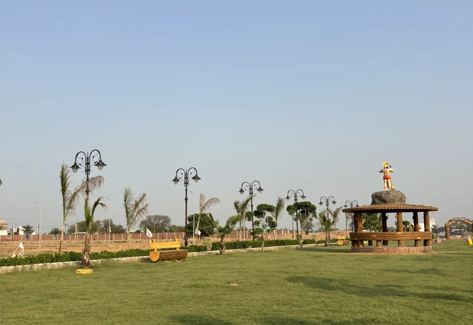 The park's wide lawn with lamps, palms and a gazebo